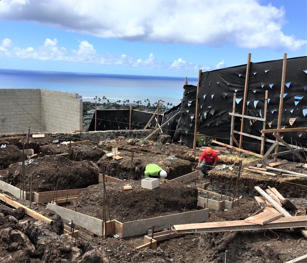 Construction guys digging to set foundation posts for a home