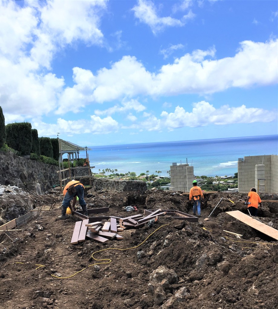 construction guys working on dirt lot to put in foundation
